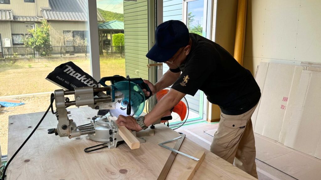 くらはし建築の大工が、電動丸ノコを使って木材を正確にカットしている作業風景。
