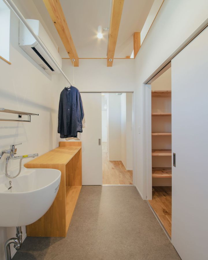 岡崎市の注文住宅、くらはし建築の施工事例。木の梁とカウンターがおしゃれな脱衣所に、快適なエアコンを設置。