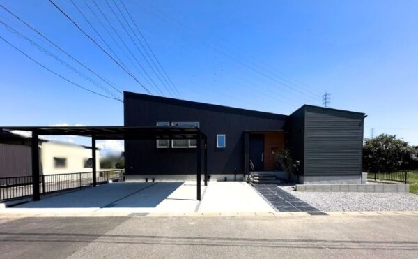 青空の下に建つ、黒いガルバリウム鋼板がシャープな平屋の外観。岡崎市中村町の完成見学会で撮影。