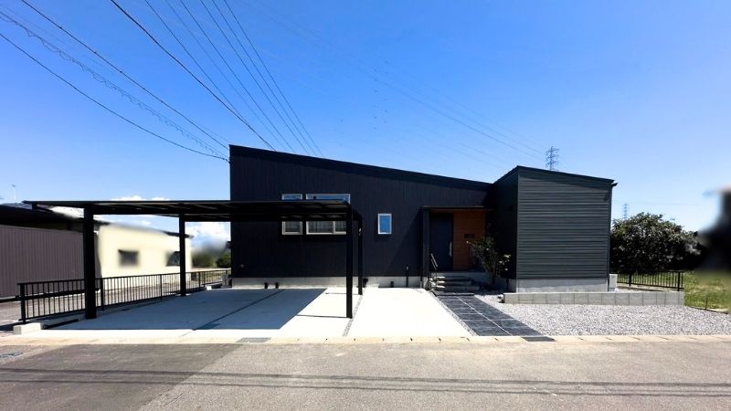 青空の下に建つ、黒いガルバリウム鋼板がシャープな平屋の外観。岡崎市中村町の完成見学会で撮影。