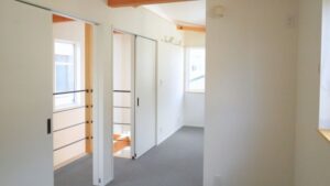 岡崎市の狭小住宅の明るい2階ホール。暗くなりがちな家の奥や2階の個室も、階段ホールからの採光や白を基調とした内装で、隅々まで光が届くよう工夫された設計例。