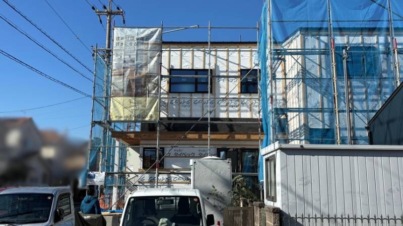 青空の下、順調に工事が進む岡崎市寿町の新築注文住宅の外観。