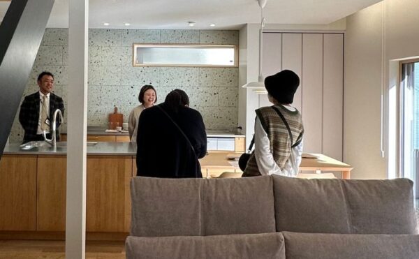 岡崎市竜美台 完成見学会 賑わうLDKとキッチンでお客様と談笑する様子