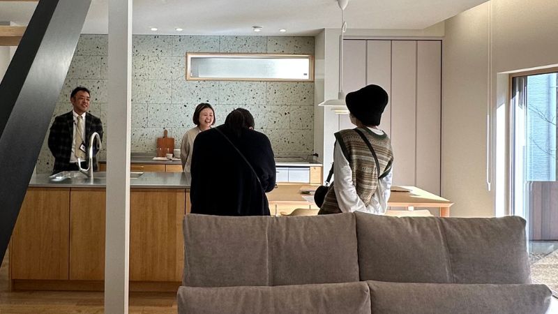 岡崎市竜美台 完成見学会 賑わうLDKとキッチンでお客様と談笑する様子