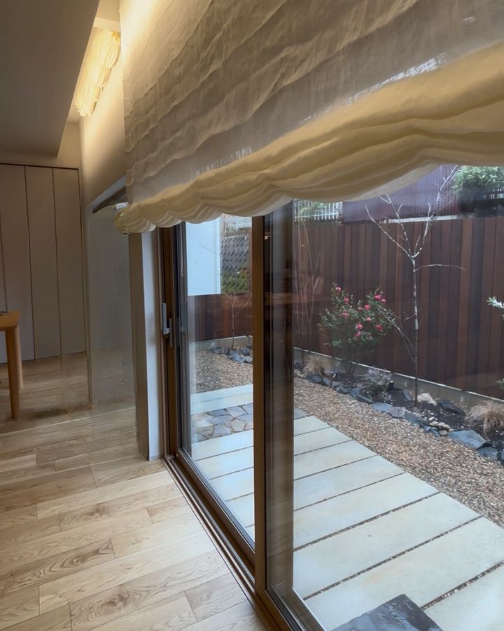 間接照明に照らされた上質な質感のシェードカーテンと、四季を感じる坪庭の眺め。