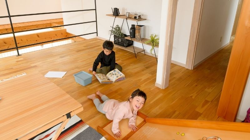 冬でも裸足で遊べる温かい無垢床のリビングで、のびのびと過ごす子供たちの様子
