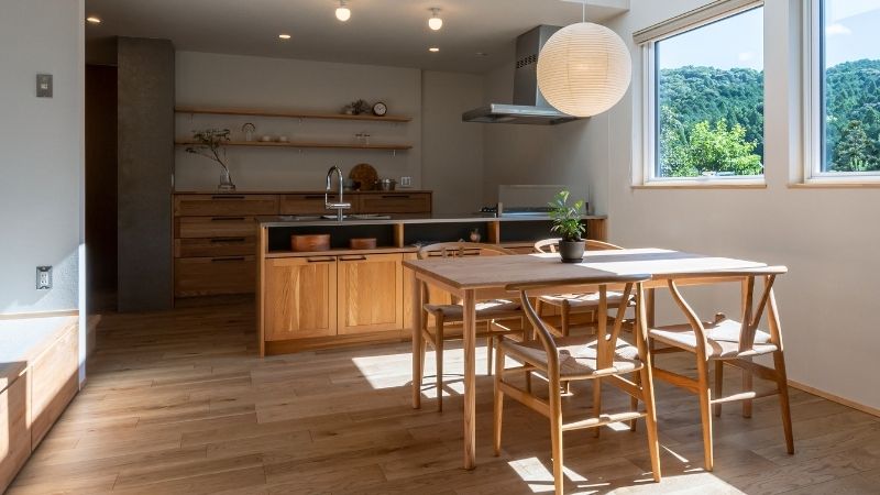 くらはし建築の注文住宅・施工事例。お料理好きなオーナー様が、あえて直火の火力を求めてガスコンロを採用したこだわりのキッチン。木の造作棚と五徳（ごとく）のある風景が調和した、温かみのある調理空間。