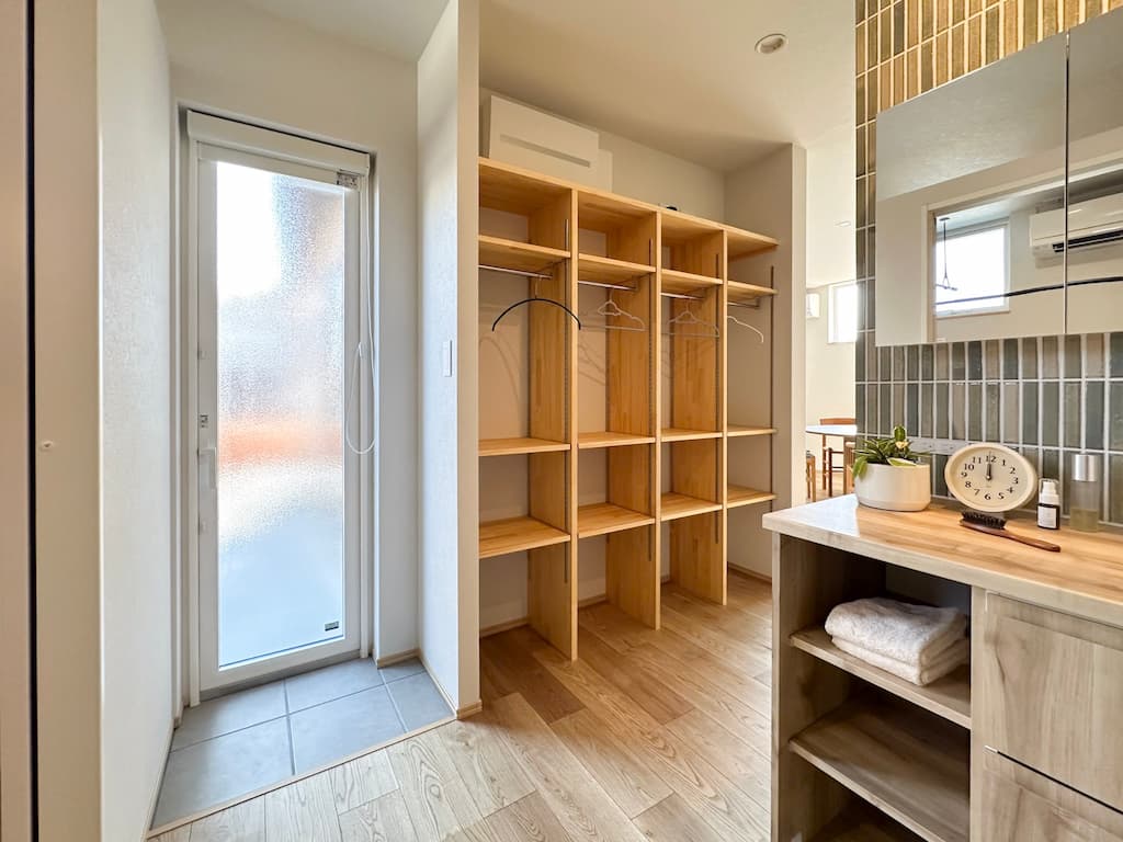  勝手口の横に設置された「家族ロッカー」。男の子3人のカバンや上着もスッキリ収まり、リビングを散らかさないための「片付く仕組み」。