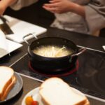 くらはし建築のコンセプトハウスに採用された、パナソニック製のトリプルワイドIHクッキングヒーター。天板との段差が一切ないフラット設計により、調理スペースを広く活用でき、お皿や食材を気軽に置ける機能的なキッチンの様子。